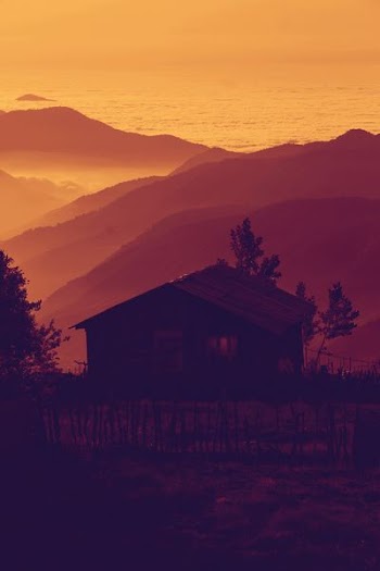 silhouette of brown house near mountains
