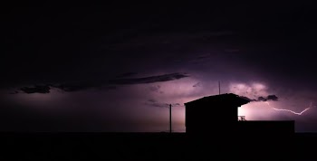 silhouette of building under cloudy sky
