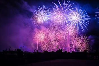 silhouette of buildings with purple and pink fireworks display