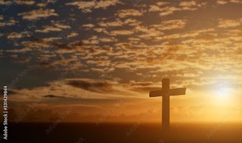 Silhouette of catholic cross at sunset background.