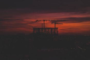 silhouette of crane at top of the building