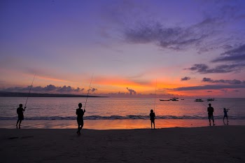Silhouette Of Five People Standing On Seashore During Sunset