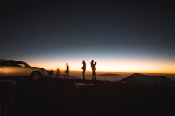 silhouette of group of people beside SUV