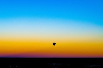 silhouette of hot air balloon under blue sky