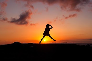 silhouette of human jumping during sunset