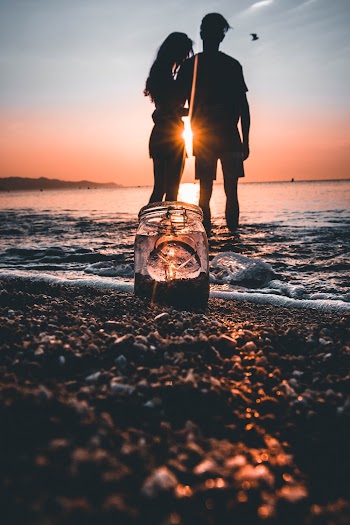 Silhouette of Man and Woman Standing on Shore