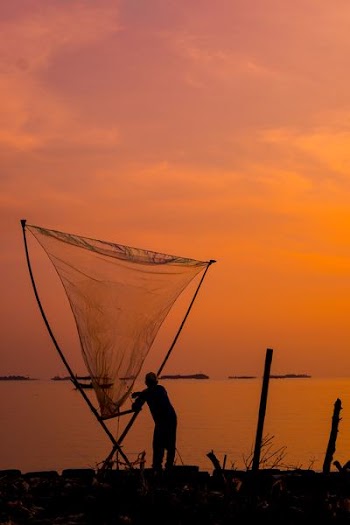 silhouette of man holding net