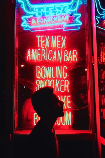 Silhouette of Man in Front of Red and Blue Led Light Signage