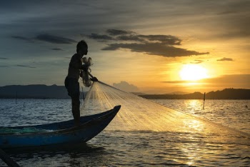 Silhouette Of Man On Boat Fishing On Body Of Water