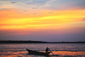 Silhouette Of Man On Boat In Water