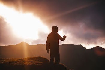 silhouette of man on cliff