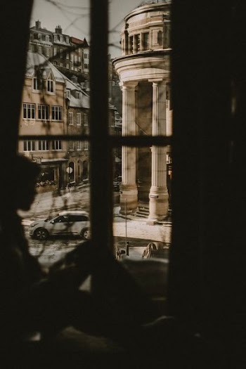 silhouette of man on window near building during daytime