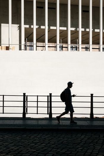silhouette of man standing beside road rail