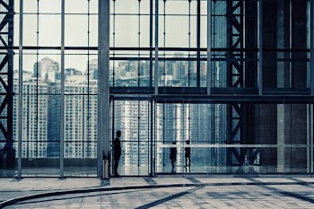 silhouette of man standing in front of curtain wall building
