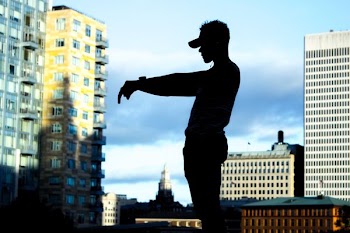 silhouette of man standing in front of high-rise buildings