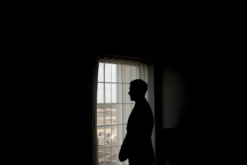 Silhouette of Man Standing in Front of Window