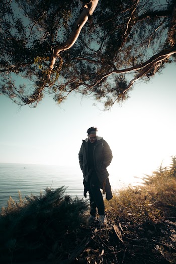 Silhouette of Man Standing Near Body of Water