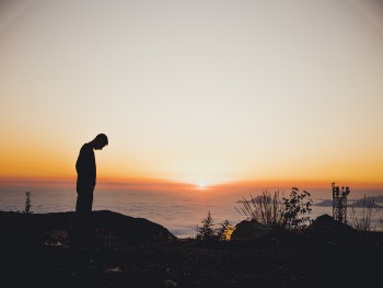 Silhouette of Man Standing Near Sea during Golden Hour