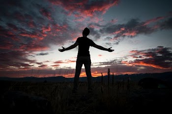 silhouette of man under white and gray sky