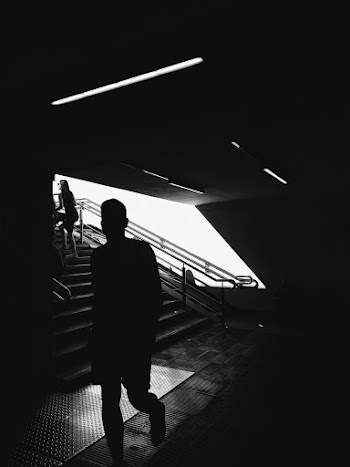 Silhouette of Man Walking Beside Stairs