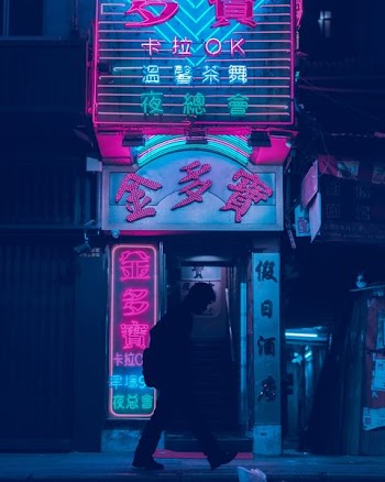 silhouette of man walking in front of store
