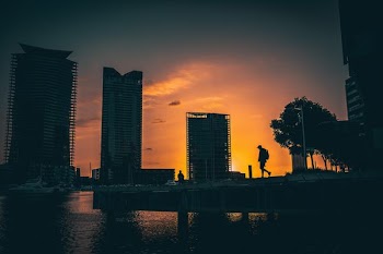 silhouette of man walking on bridge