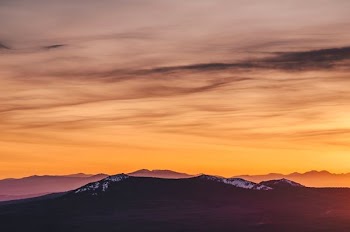 silhouette of mountain during yellow cloudy skies
