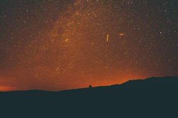 silhouette of mountain under milky way at night time