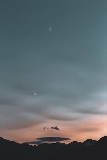 silhouette of mountain under pale evening sky