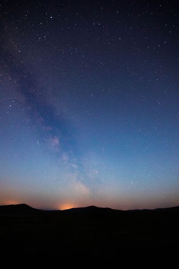 silhouette of mountainous terrain under milky way