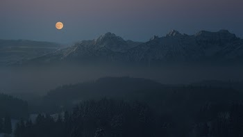 Silhouette of Mountains Covered With Light Mist Under The Full Moon