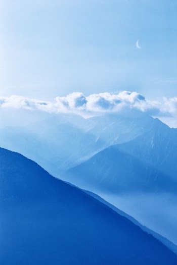 silhouette of mountains under cloudy sky