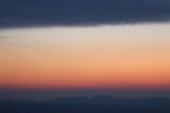silhouette of mountains under gray and orange sky during sundown