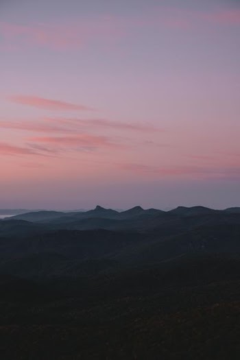 silhouette of mountains under pink sky