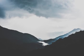 silhouette of mountains under white sky