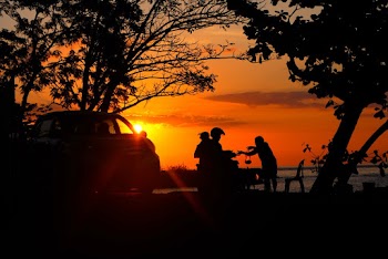 Silhouette of People Near Car And A Body of Water
