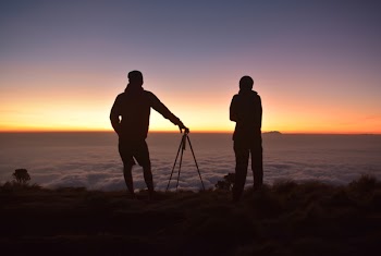 Silhouette of People on Mountain Tops Looking on Sea of Clouds