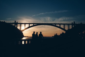 Silhouette of People Standing Near the Bridge