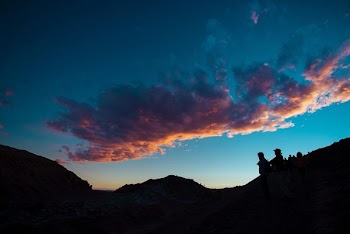 silhouette of people under cloudy sky