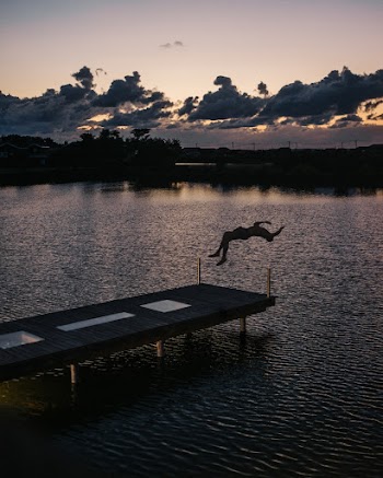 Silhouette Of Person Back Flipping On Body Of Water