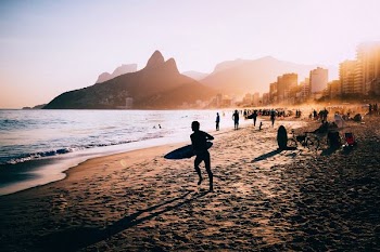 silhouette of person holding surfboard