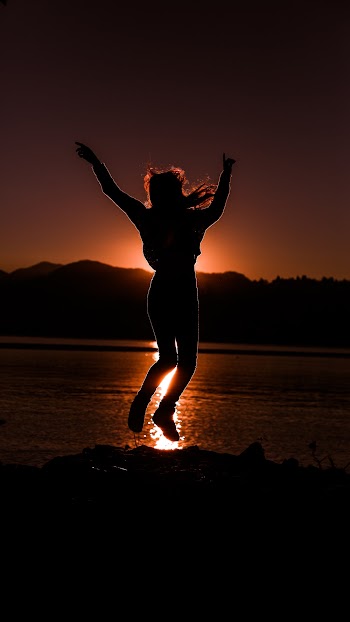 Silhouette of Person Jumping Near Body of Water