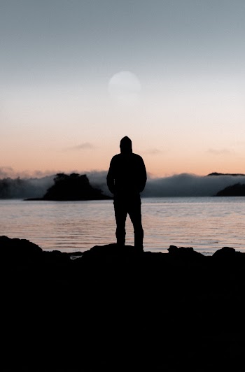 Silhouette of Person on Top of Rock Formation