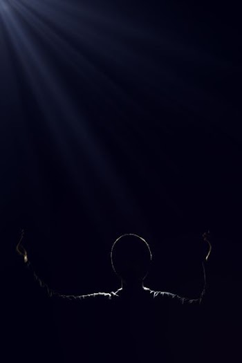 silhouette of person raising two hands