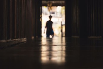 silhouette of person standing beside wall