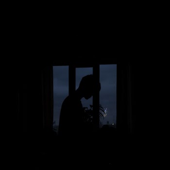 Silhouette of Person Standing Near Window