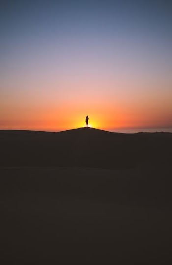 silhouette of person standing on hill