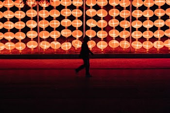 silhouette of person walking near lantern lamp