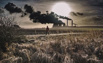 silhouette of person walking on pathway near factory