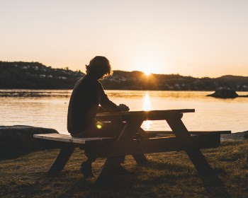 Silhouette of Persons Sitting on Picnic Table